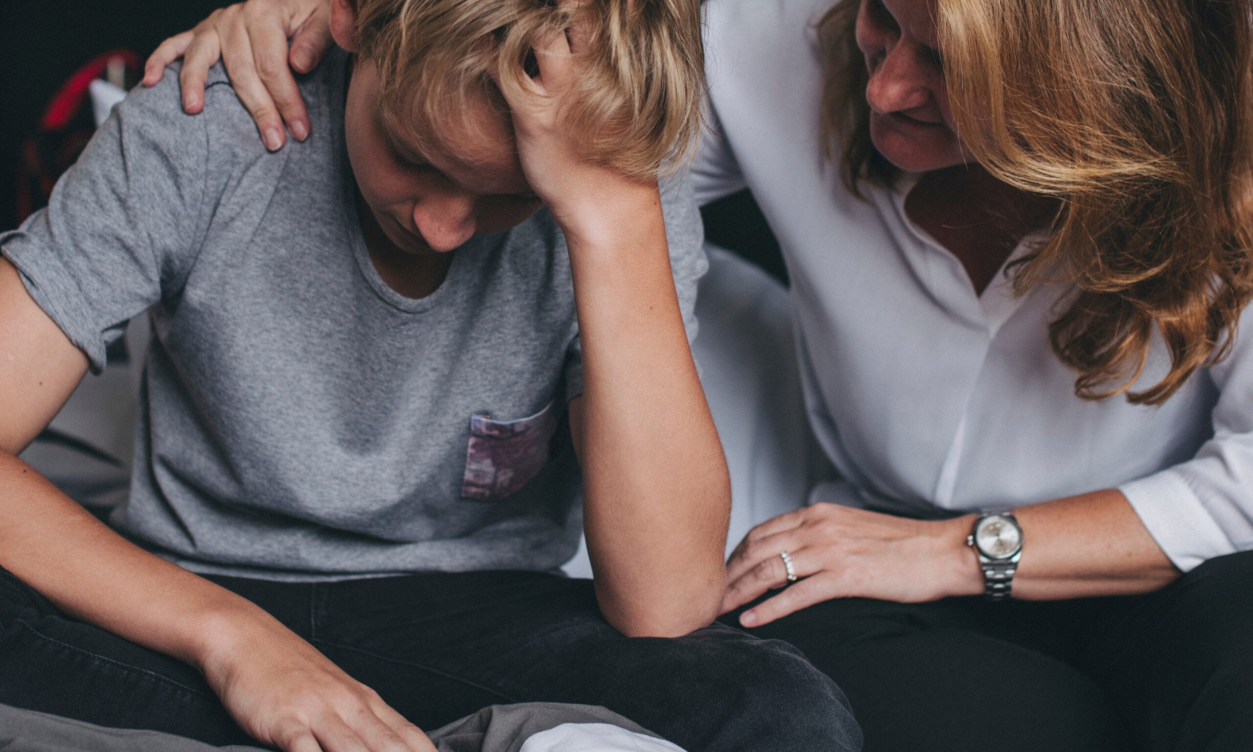Parent comforting a distressed child while recognizing warning signs of anxiety and depression in children.