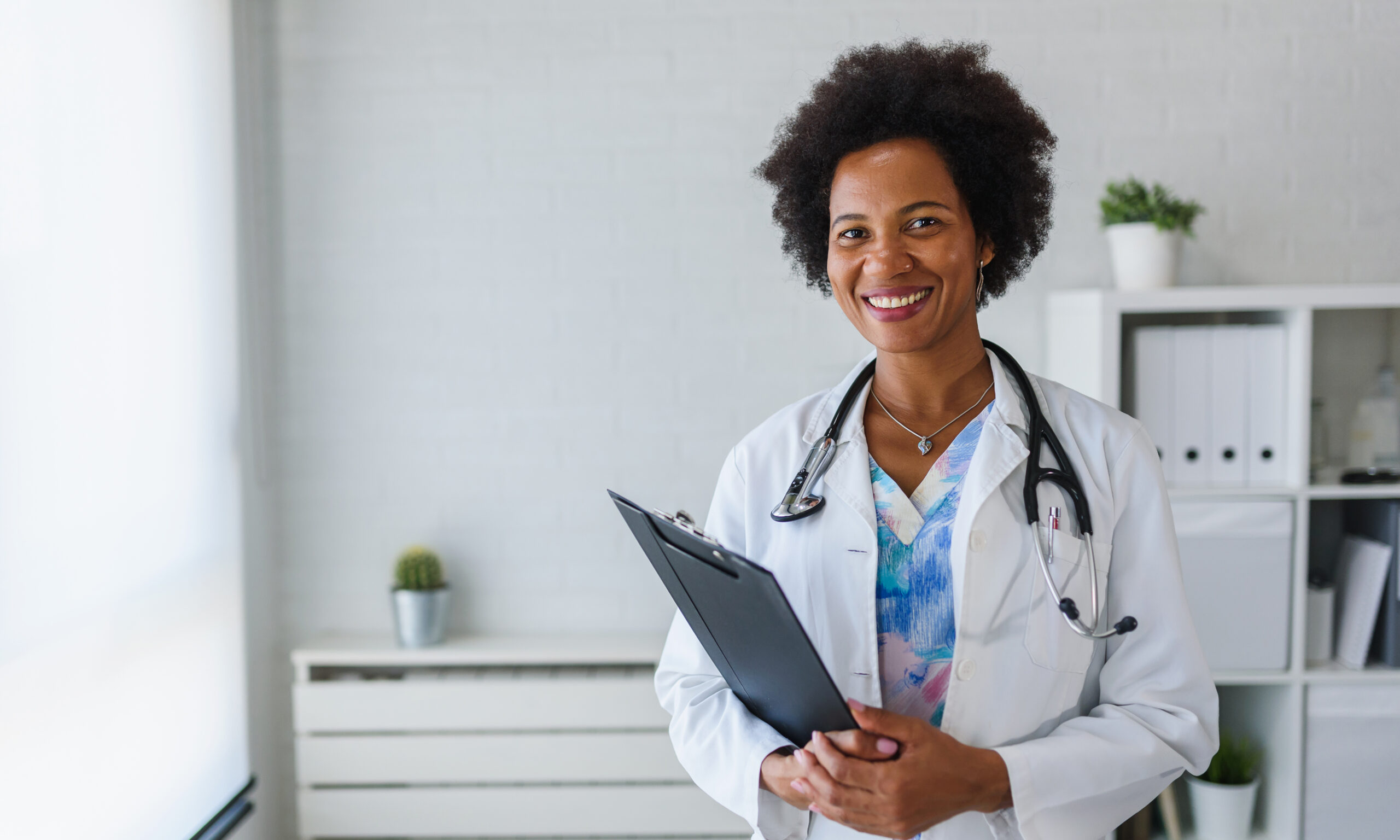 Female doctor with stethoscope holding clipboard in clinic representing Medi-Cal doctors near Upland California