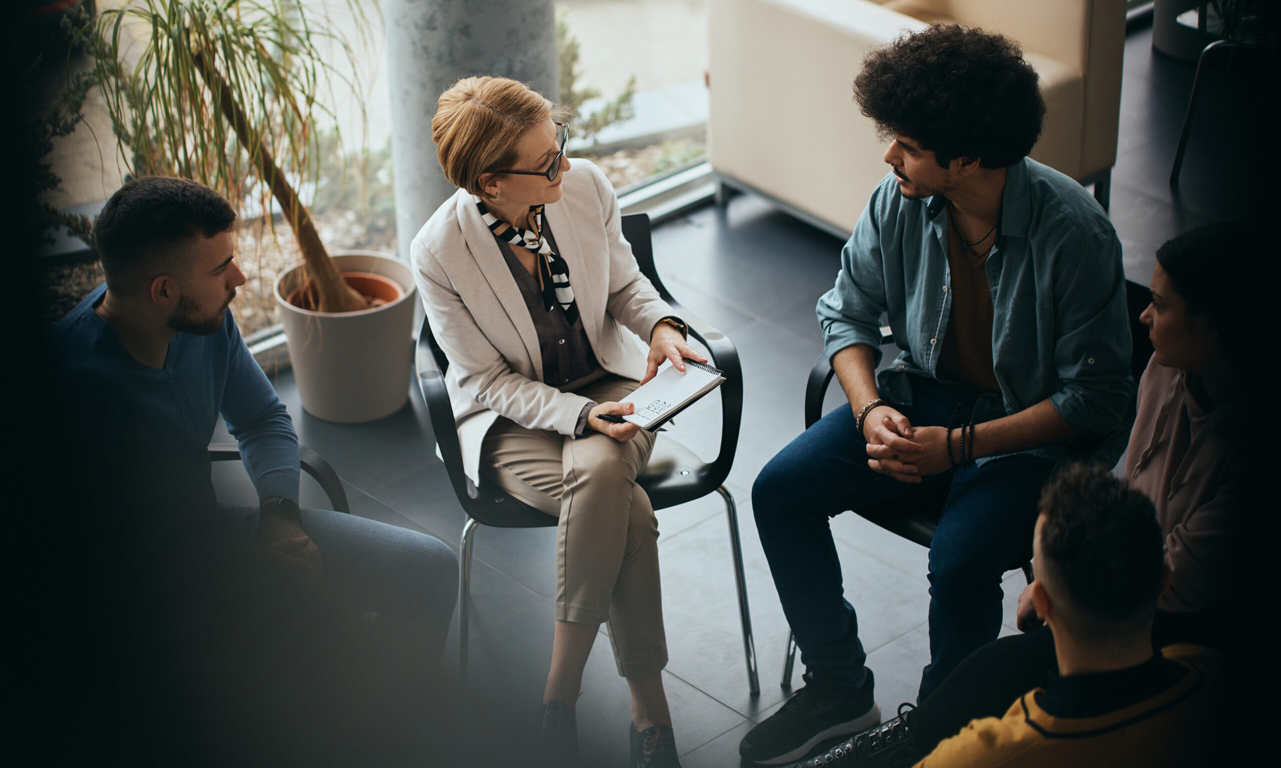 Mental health professional leading a discussion with a small group, representing different types of mental health care including therapy, counseling, and psychiatric services.