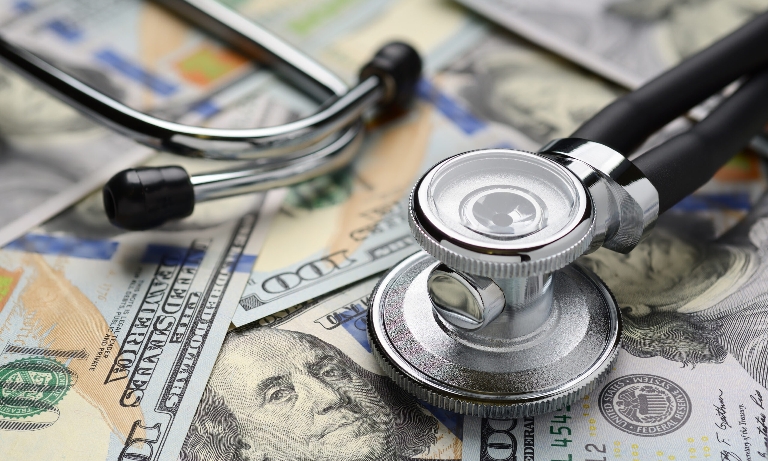 Stethoscope placed on US dollar bills representing healthcare costs and financial assistance options in San Bernardino County