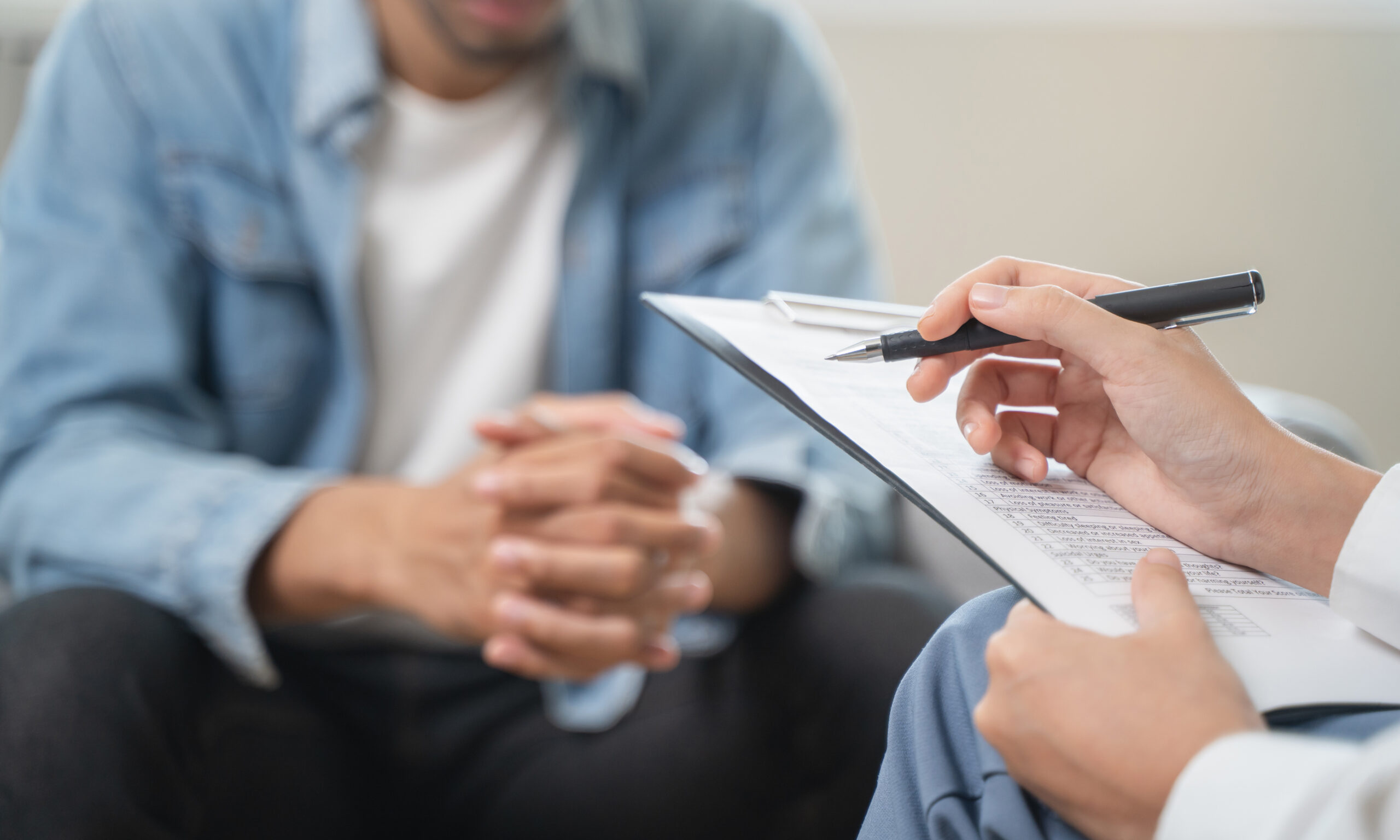 Patient speaking with a healthcare professional while reviewing paperwork about accessing mental health services through Medi-Cal coverage.