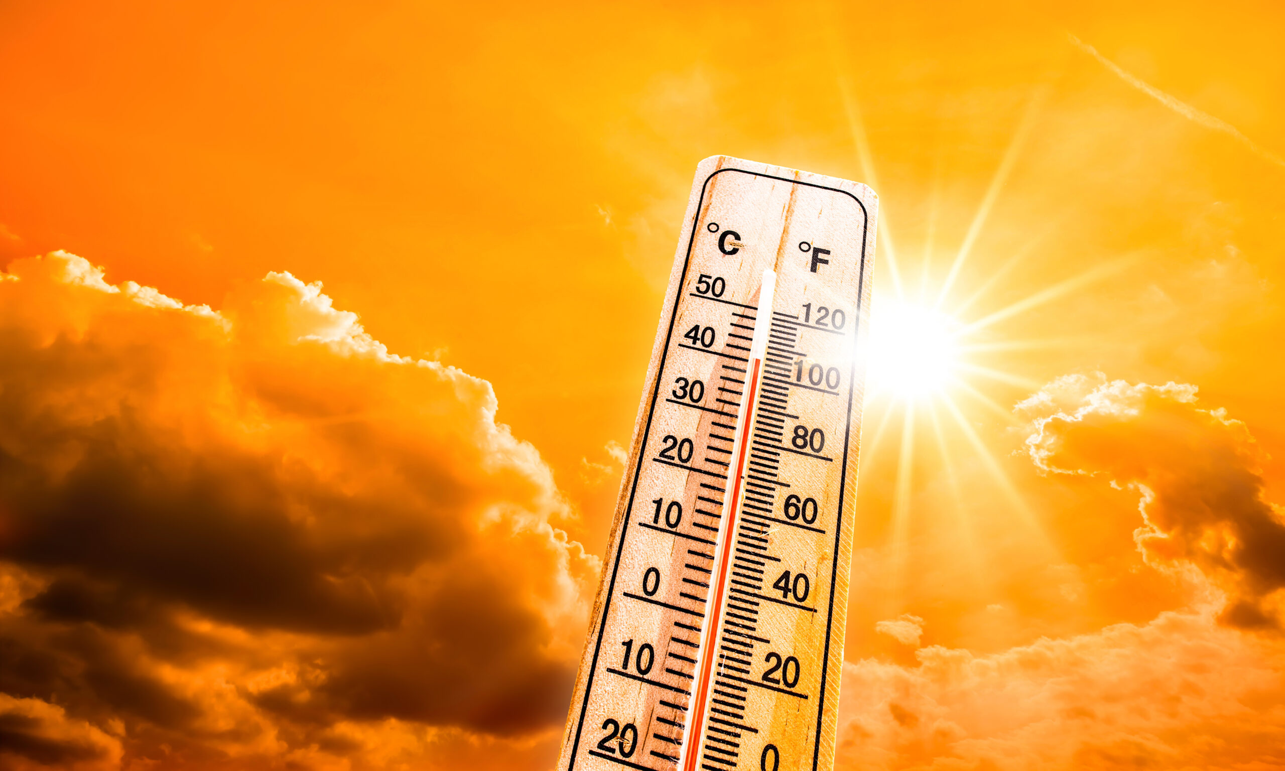 Thermometer showing high temperatures under bright sunlight, representing dangerous heat conditions and the risk of heat-related illness.